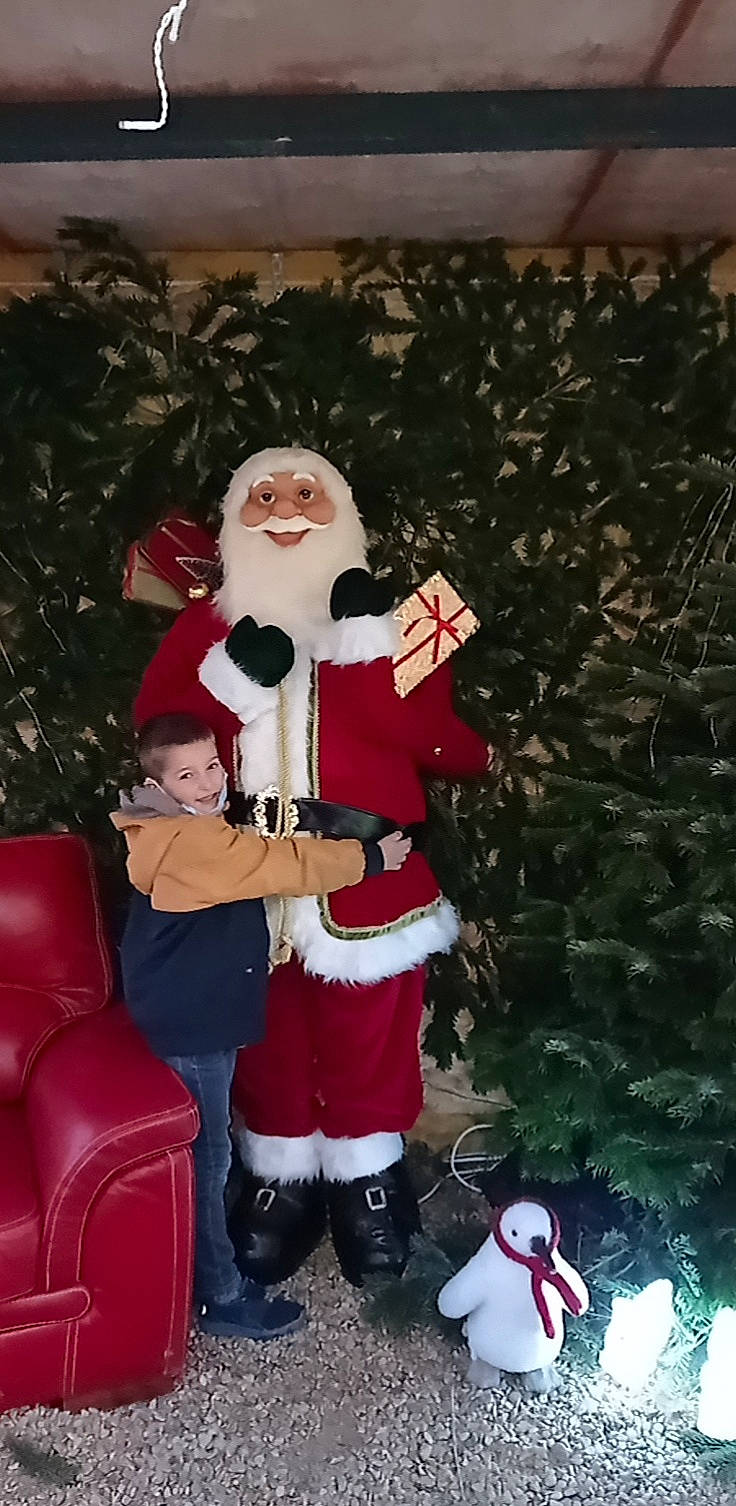 Aron a rejoint le concours — aidez-le/la à gagner de superbes lots ! beard, boot, christmas, christmas_decoration, christmas_lights, christmas_ornament, costume_hat, event, fictional_character, fun, happy, hat, holiday, holiday_ornament, joy, lap, ornament, person, plant, santa_claus