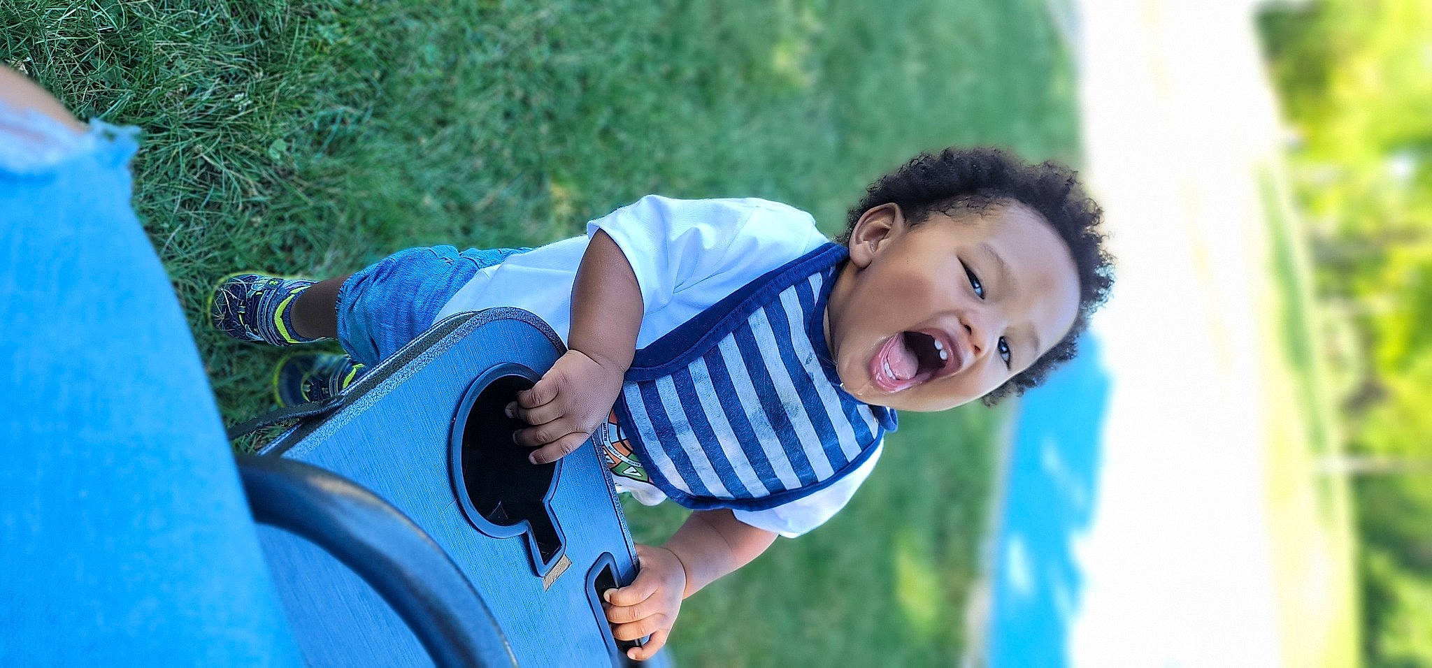 Jace is registered to the contest to win money with this photo: automotive_exterior, bumper, child, denim, electric_blue, flash_photography, fun, grass, happy, leisure, motor_vehicle, person, plant, recreation, sitting, smile, sunglasses, t_shirt, toddler, tree