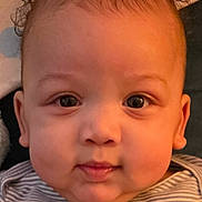 Logan is registered to the contest to win money with this photo: baby, infant, face, curly_hair, striped_shirt, close_up, child, portrait, cute, looking_at_camera, indoor, skin, young_child, head, expression, person, young_baby, cheeks, eyes, soft_background