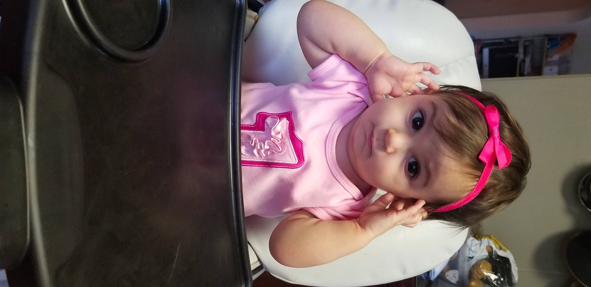 Vienna is registered to the contest to win money with this photo: arm, baby, black_hair, cheek, child, ear, electronic_device, mouth, person, pink, play, technology, toddler