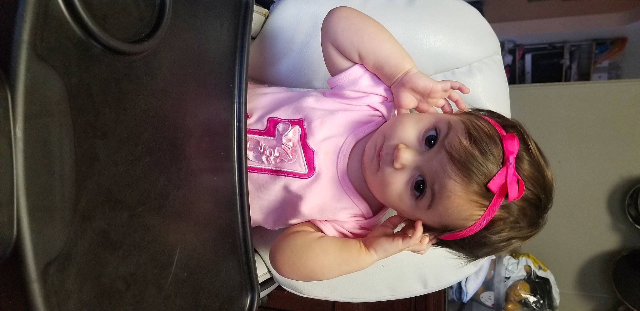 Vienna is registered to the contest to win money with this photo: arm, baby, black_hair, car_seat, cheek, child, ear, leg, mouth, neck, person, pink, skin, toddler