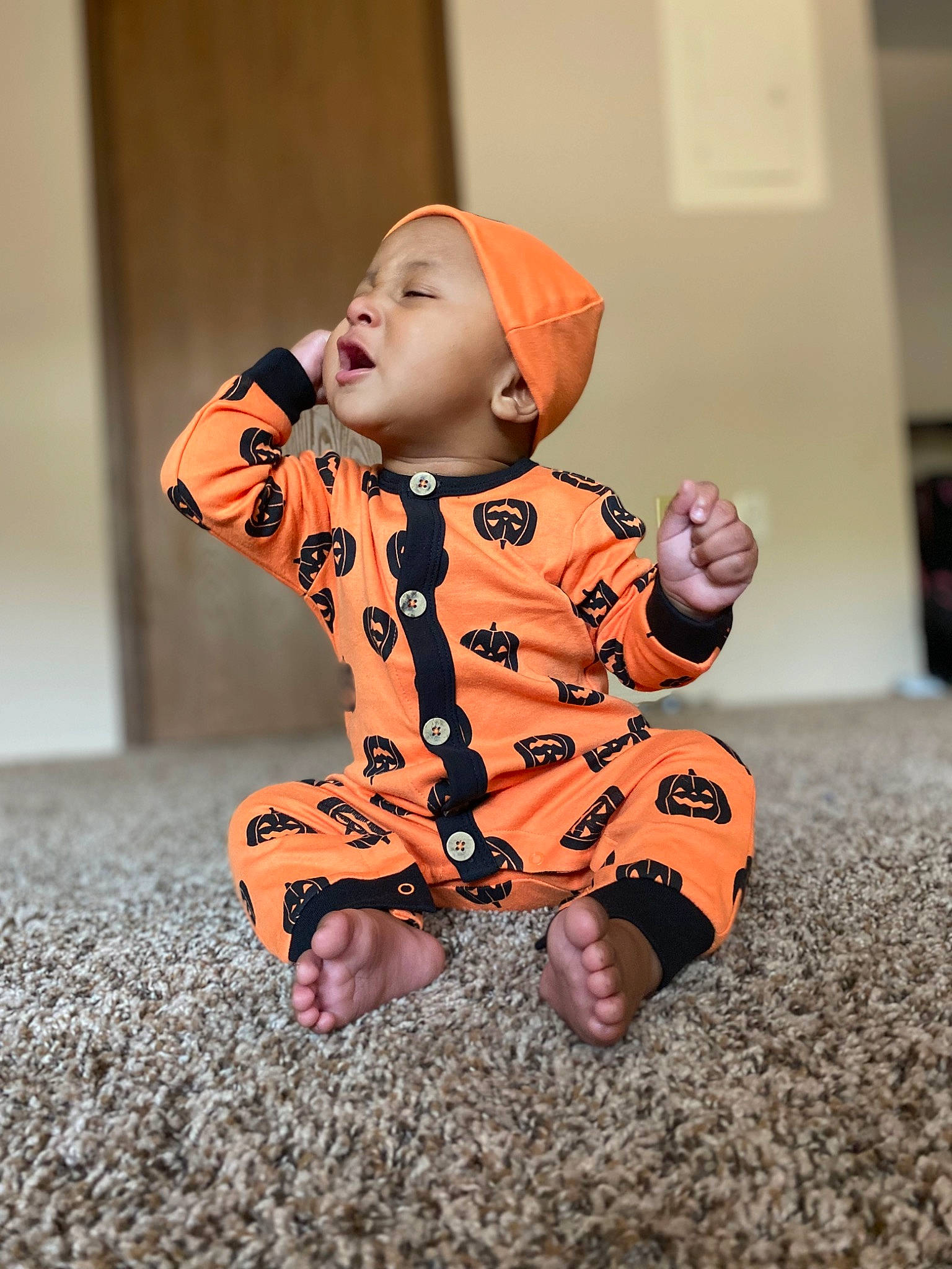 Damarious joined the competition — help win amazing prizes! baby, baby_toddler_clothing, cheek, child, collar, face, flooring, fun, fur, gesture, happy, hat, headwear, human_leg, orange, pattern, person, sitting, sleeve, thumb