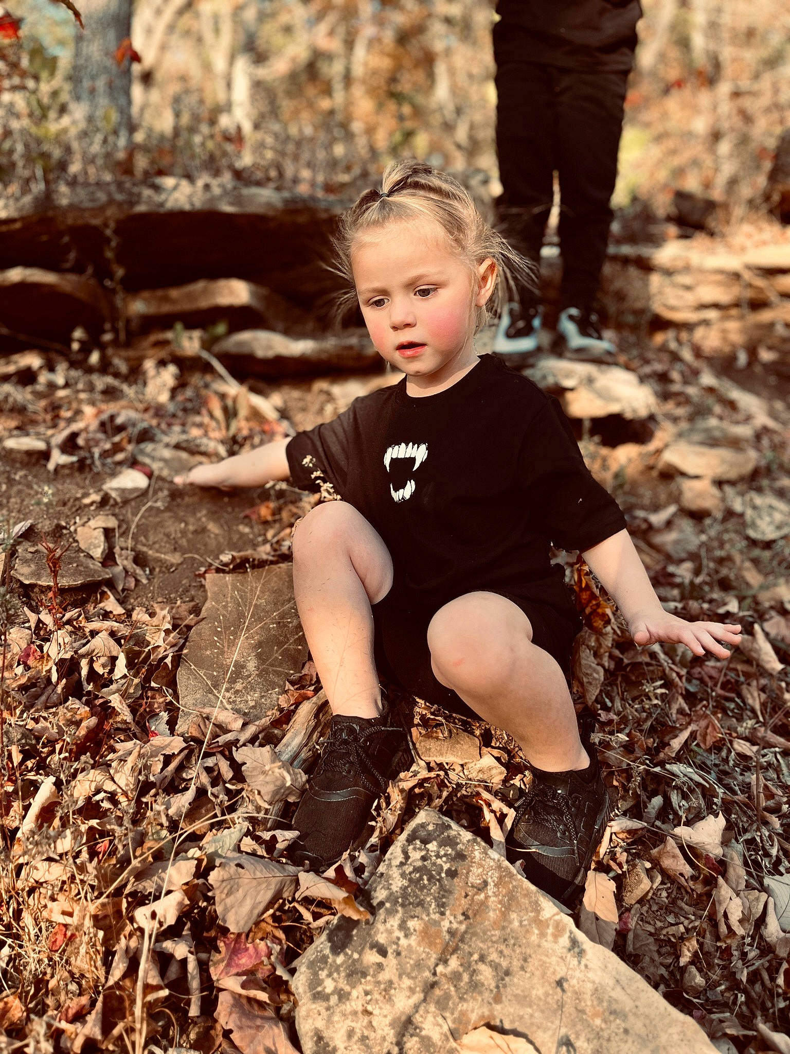 Maya joined the competition — help win amazing prizes! blond, boot, flash_photography, forest, fun, grass, happy, human_leg, leg, monochrome, people_in_nature, person, rock, shoe, sitting, soil, t_shirt, thigh, toddler, wood