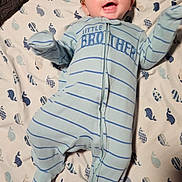 Michael is registered to the contest to win money with this photo: baby, infant, smiling, onesie, striped_clothing, blue_clothing, blanket, whale_pattern, happy, lying_down, face, arm_movement, footed_pajamas, cute, child, cheerful, indoor, soft_texture, fabric, sleepwear