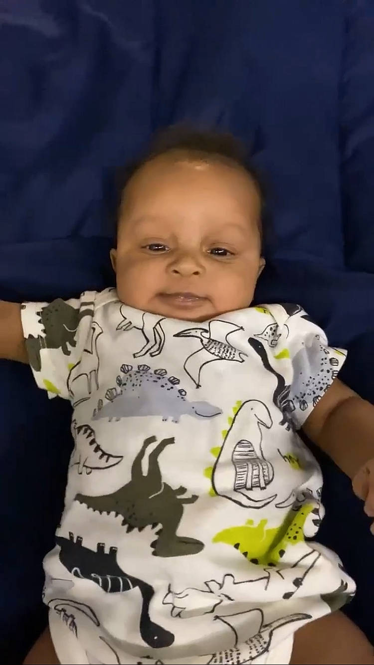 Messiah is registered to the contest to win money with this photo: baby, baby_products, baby_toddler_clothing, cheek, child, chin, comfort, eye, facial_expression, happy, iris, lip, mouth, neck, nose, person, sitting, skin, sleeve, t_shirt