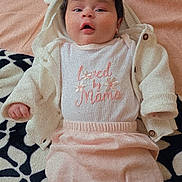 Kamyah is registered to the contest to win money with this photo: baby, infant, clothing, jacket, blanket, pattern, face, expression, lying_down, pastel_colors, cute, soft_texture, child, socks, warm, portrait, indoor, young, adorable, comfort