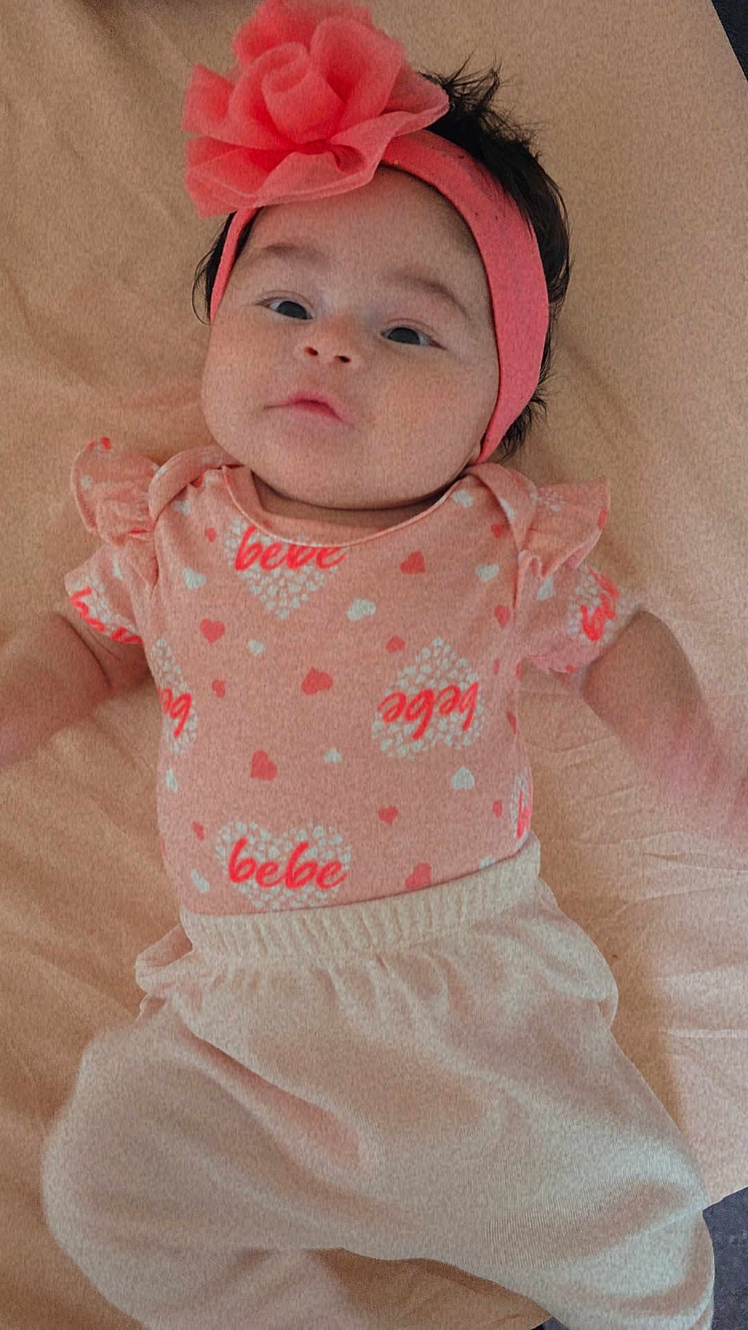 Kamyah is registered to the contest to win money with this photo: baby, infant, headband, flower, pink, clothing, lying_down, blanket, cute, child, portrait, soft_texture, heart_pattern, young_child, casual_clothing, indoor, person, small_child, adorable, fashion