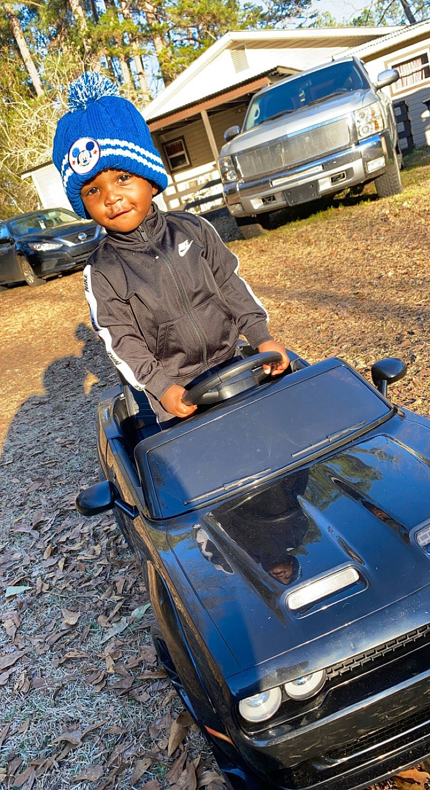 Jesiah is registered to the contest to win money with this photo: asphalt, automotive_design, automotive_exterior, automotive_lighting, automotive_tire, blue, bumper, cap, car, fender, headwear, helmet, hood, land_vehicle, mode_of_transport, motor_vehicle, person, smile, tire, travel