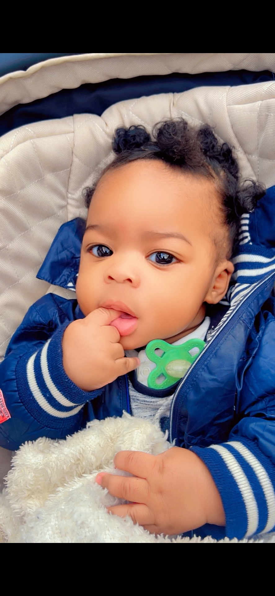 Loevan a rejoint le concours — aidez-le/la à gagner de superbes lots ! baby, child, cute, curly_hair, blue_jacket, blanket, pacifier, hand, face, portrait, indoors, closeup, infant, warm_clothing, soft_texture, cozy, young_child, expression, skin, person