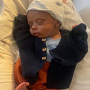 Zaïm participe au concours pour gagner de l'argent avec cette photo : baby, sleeping, infant, hat, cardigan, pants, blanket, cozy, cute, foot, hand, indoors, resting, child, soft, comfort, portrait, newborn, peaceful, clothing