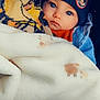 baby, child, blanket, beanie, hat, mickey_mouse, blue_eyes, coat, denim_jacket, warm_clothing, portrait, face, cute, infant, cozy, soft_texture, indoor, closeup, expression, wrapped