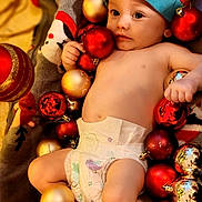 Noah participe au concours pour gagner de l'argent avec cette photo : baby, blanket, celebration, child, christmas_ornaments, colorful, cute, decorations, diaper, festive, holiday, holiday_season, indoors, infant, playful, portrait, red_hat, relaxing, smiling, soft_texture