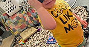 Braxley is registered to the contest to win money with this photo: blanket, carpet, child, clothing, cute, indoor, laundry_basket, messy, person, plaything, portrait, room, smiley_face, sneakers, standing, sunglasses, toddler, toy, toy_zebra, yellow_shirt