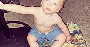 Braxley is registered to the contest to win money with this photo: toddler, child, carpet, rug, laundry_basket, clean_clothes, indoor, floor, shorts, bare_chest, blurry, standing_lamp, cord, colorful, patterned, hand, reaching, heart_emoji, timestamp, home