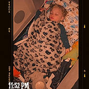 Braxley is registered to the contest to win money with this photo: toddler, sleeping, blanket, plush_toy, bed, child, indoors, cozy, nap, soft_lighting, pattern, comfort, cute, peaceful, portrait, rest, young_child, sleepwear, toy, warm_tone