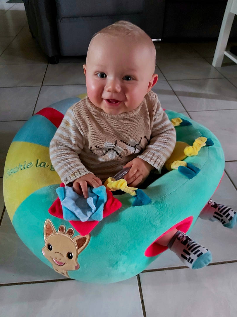Aaron participe au concours pour gagner de l'argent avec cette photo : baby, baby_playing_with_toys, baby_products, baby_toddler_clothing, baby_toys, cheek, child, comfort, flooring, fun, happy, head, joy, leisure, person, pink, play, sitting, sleeve, smile