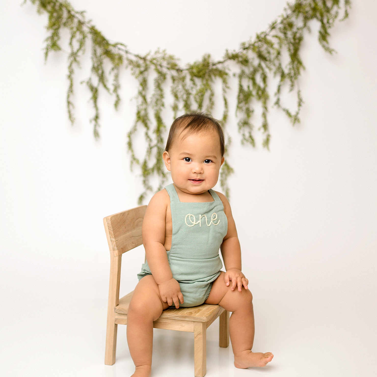 Leonard Van joined the competition — help win amazing prizes! baby, barefoot, child, clothing, cute, decor, garland, greenery, happy, infant, light_background, milestone, one_year_old, portrait, sitting, small_chair, smiling, studio, wooden_chair, young