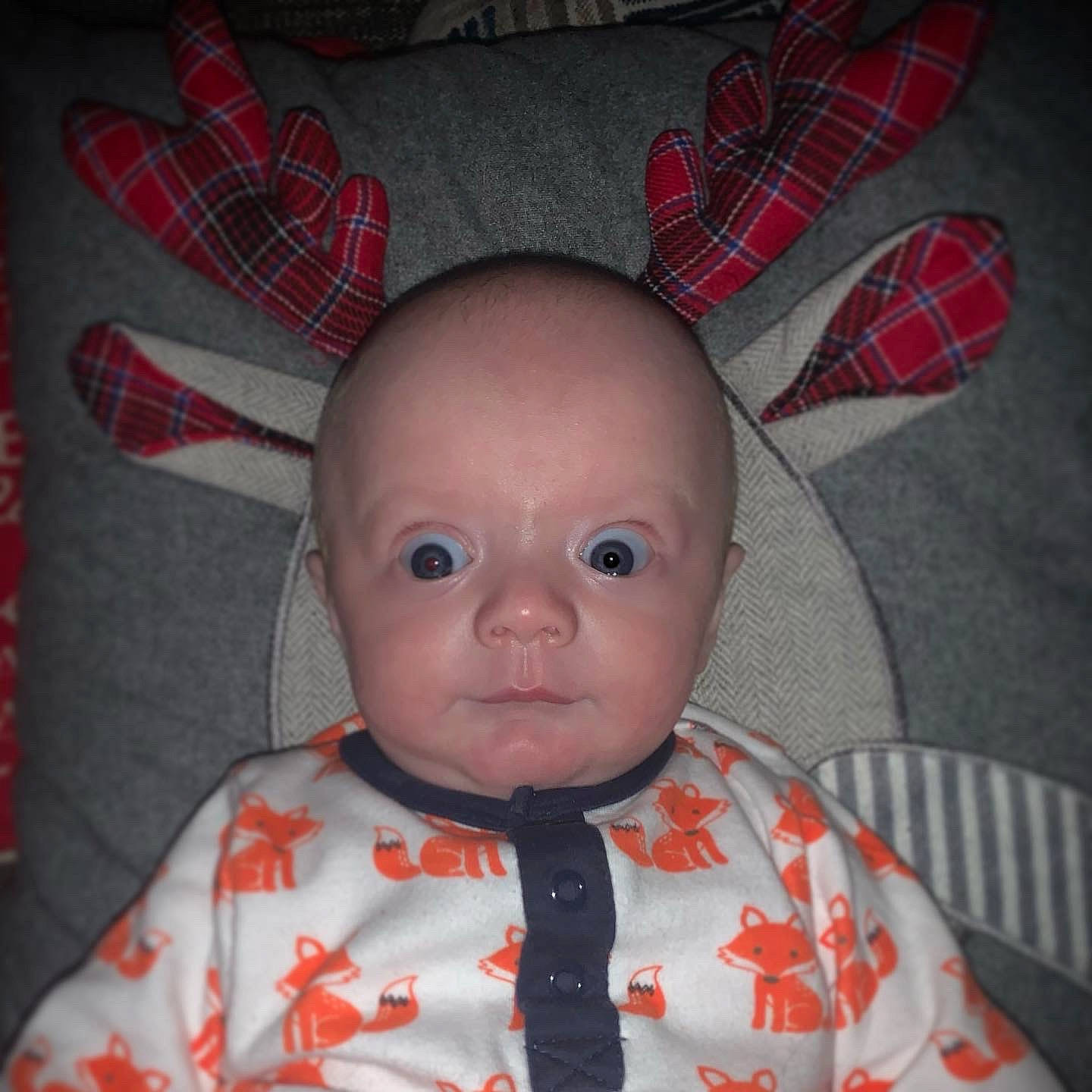 Harrison is registered to the contest to win money with this photo: baby, baby_products, baby_toddler_clothing, carmine, cheek, coquelicot, forehead, iris, linens, lip, pattern, peach, person, plaid, red, skin, tartan, textile