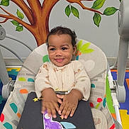 Roy is registered to the contest to win money with this photo: toddler, child, baby_seat, craft, rocket, handmade, clapping, smiling, tree_mural, wall_painting, indoor, play_area, colorful, floor_mat, happy, person, infant, cute, young_child, artwork