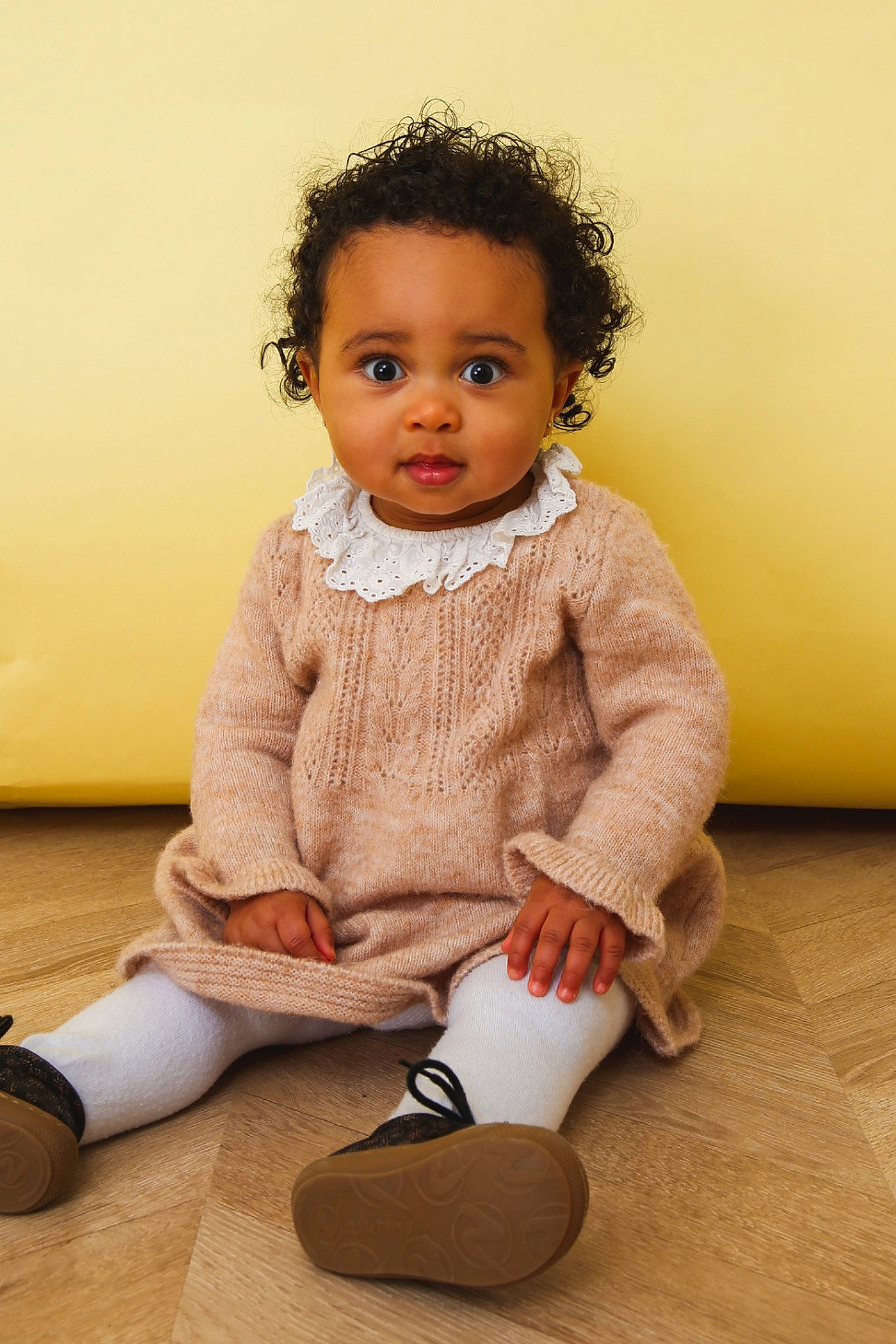 Iris participe au concours pour gagner de l'argent avec cette photo : baby, baby_toddler_clothing, cheek, child, collar, eye, face, flash_photography, floor, flooring, happy, hardwood, head, knee, person, sitting, skin, sleeve, standing, toddler