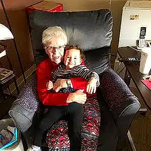 Saylor joined the competition — help win amazing prizes! baby, chair, child, comfort, event, eyewear, fun, happy, holiday, knee, lamp, lap, leisure, living_room, person, room, sitting, smile, thigh, toddler