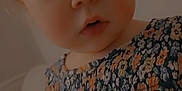 Lana is registered to the contest to win money with this photo: child, toddler, face, blue_eyes, curly_hair, floral_dress, patterned_clothing, indoor, soft_lighting, portrait, baby, person, cute, young_child, skin, cheeks, focus, expression, clothing, background