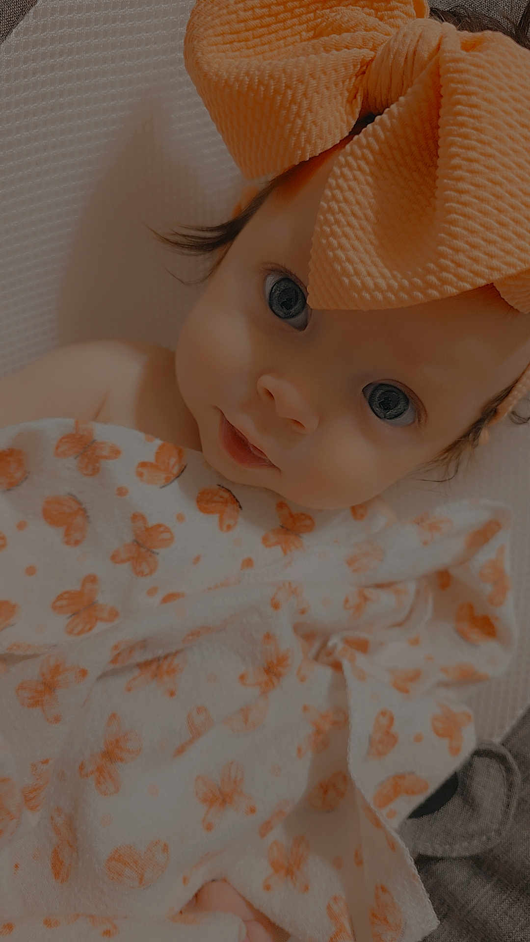 Kaylie is registered to the contest to win money with this photo: baby, infant, blanket, bow, orange, face, eyes, cute, child, portrait, soft, fabric, pattern, closeup, headwear, newborn, wrapped, skin, expression, lying_down