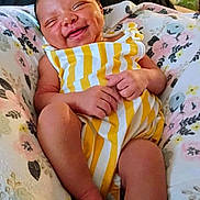 Ariya is registered to the contest to win money with this photo: baby, child, comfortable, cushion, cute, floral_pattern, happy, indoors, infant, legs, lying_down, newborn, peaceful, portrait, relaxed, sleepy_eyes, small_hands, smiling, soft_lighting, striped_clothing