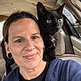 Salem is registered to the contest to win money with this photo: person, cat, black_cat, pet, car_interior, car_seat, vehicle_window, cat_collar, cat_bell, close_up, portrait, eyes, black_fur, human_face, smile, ear_gauges, hoodie, headrest, upholstery, seat_back