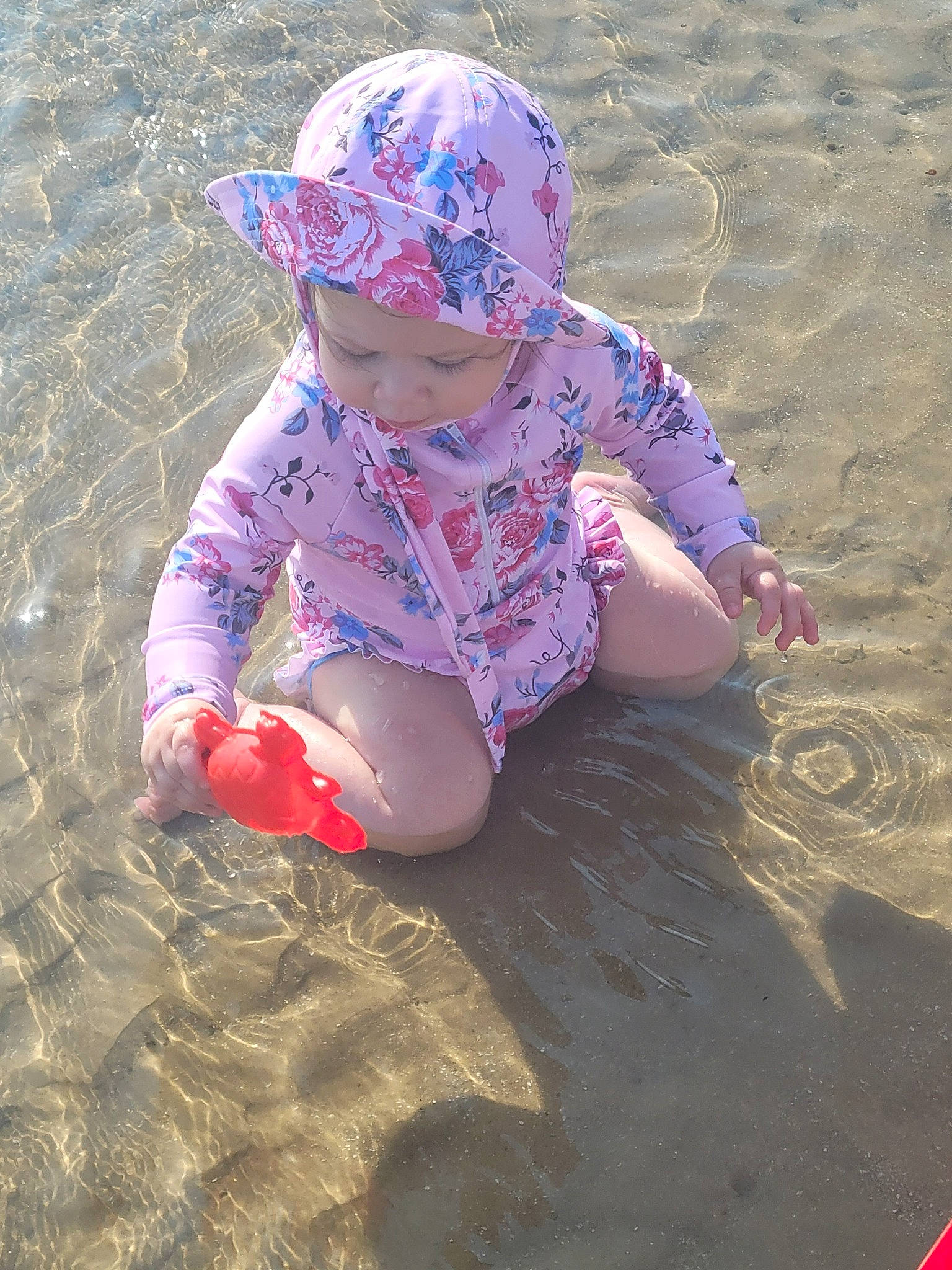 Amelia joined the competition — help win amazing prizes! baby, baby_toddler_clothing, beach, cap, carmine, child, fun, hat, headwear, magenta, ocean, pattern, people_in_nature, person, personal_protective_equipment, play, recreation, sand, shadow, sitting