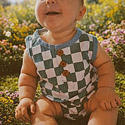 Silas joined the competition — help win amazing prizes! baby, infant, smiling, checkered_outfit, buttons, sitting, chubby_arms, legs, grass, flowers, outdoor, sunlight, portrait, closeup, happy, nature, garden, shoe, cute, skin