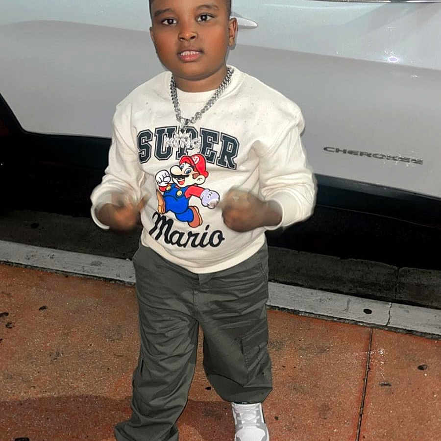 Joon Oakley is registered to the contest to win money with this photo: boy, car, casual_clothing, chain_necklace, child, motion_blur, night, outdoor, pants, parking_lot, person, portrait, sidewalk, sneakers, standing, street, super_mario, sweatshirt, urban, white_suv