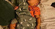 Derrell is registered to the contest to win money with this photo: baby, sleeping, blanket, bed, pillow, clothing, footwear, socks, infant, peaceful, indoors, cozy, rest, person, portrait, soft, comfort, cute, child, lying_down