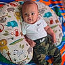 Derrell joined the competition — help win amazing prizes! baby, infant, child, pillow, animal_print, blanket, colorful, white_shirt, nike_logo, camo_pants, socks, cute, smiling, face, eyes, indoors, soft_toys, patterned, relaxing, portrait