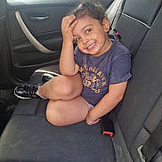 Naelya participe au concours pour gagner de l'argent avec cette photo : backseat, car_interior, casual_clothing, child, cute, daylight, girl, hair_braids, happy, indoors, person, playful, portrait, seat, seatbelt, shoe, sitting, smiling, window, young