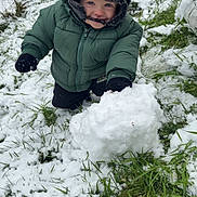 Raphaël a rejoint le concours — aidez-le/la à gagner de superbes lots ! child, cold_weather, fence, gloves, grass, green_jacket, happy, hat, nature, outdoor, person, play, portrait, seasonal, smiling, snow, snowball, toddler, winter_clothing, young_child