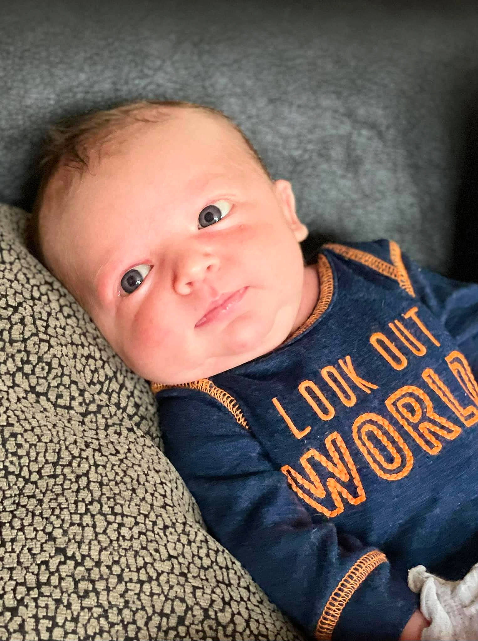 Ganon is registered to the contest to win money with this photo: baby, baby_toddler_clothing, cheek, child, chin, comfort, eye, flash_photography, flooring, fun, happy, head, linens, long_sleeved_t_shirt, nose, person, skin, sleeve, smile, t_shirt
