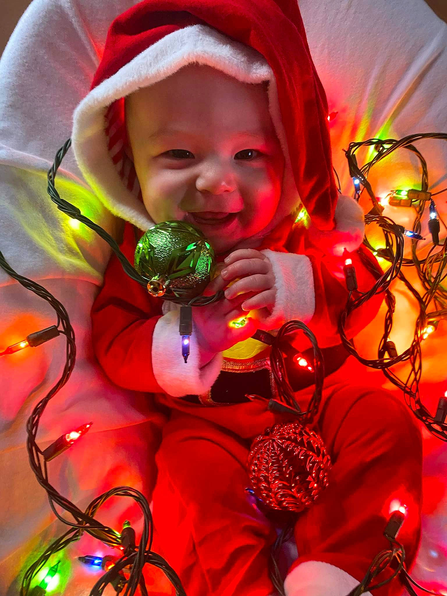 Colson is registered to the contest to win money with this photo: beauty, christmas_decoration, christmas_ornament, event, eye, fun, happy, head, headwear, holiday, light, magenta, organism, ornament, person, pink, plant, purple, red, smile