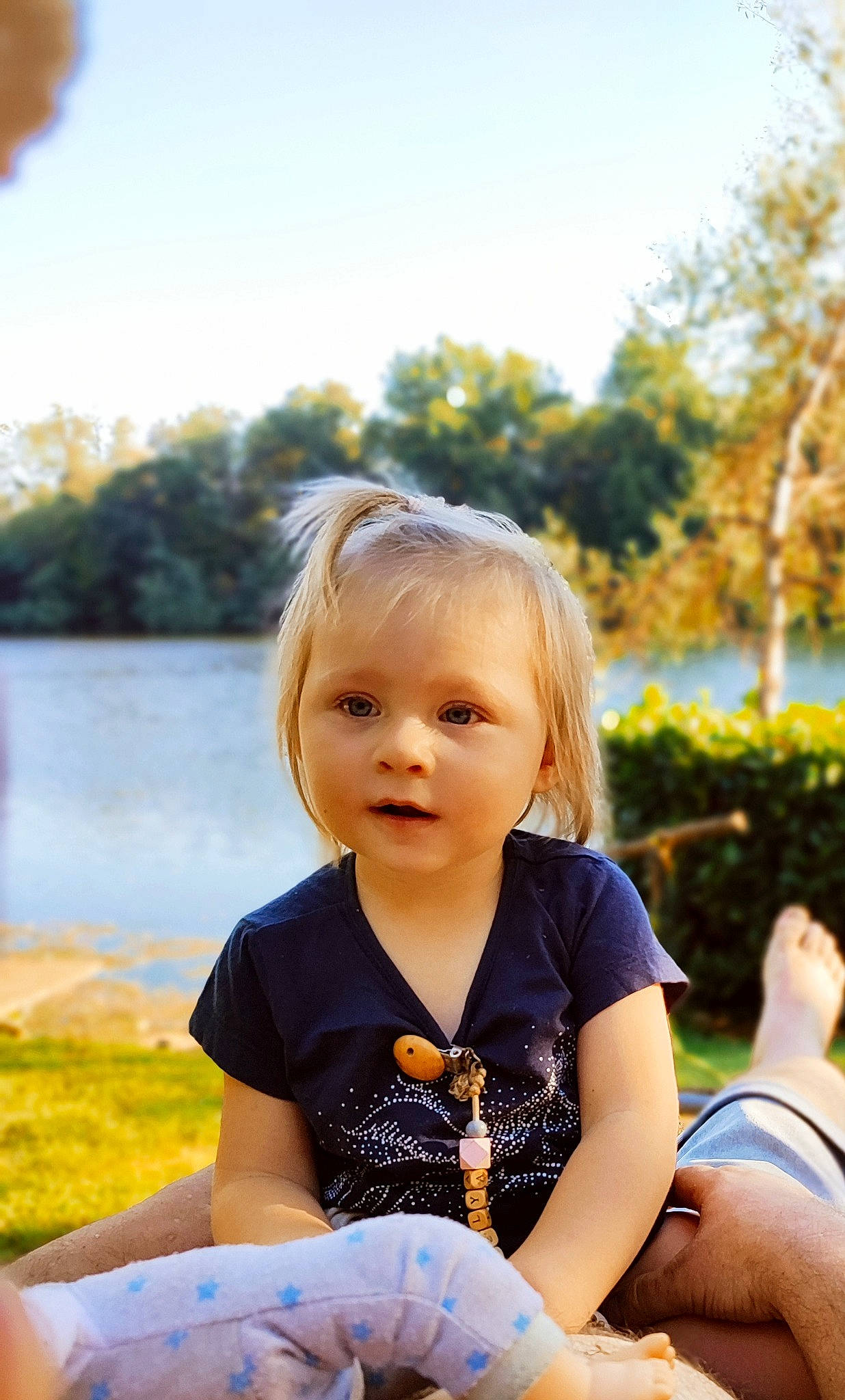 Noëlya participe au concours pour gagner de l'argent avec cette photo : child, daytime, face, flash_photography, fun, grass, happy, lake, leaf, leisure, people_in_nature, person, plant, recreation, sitting, sky, spring, sunlight, toddler, tree