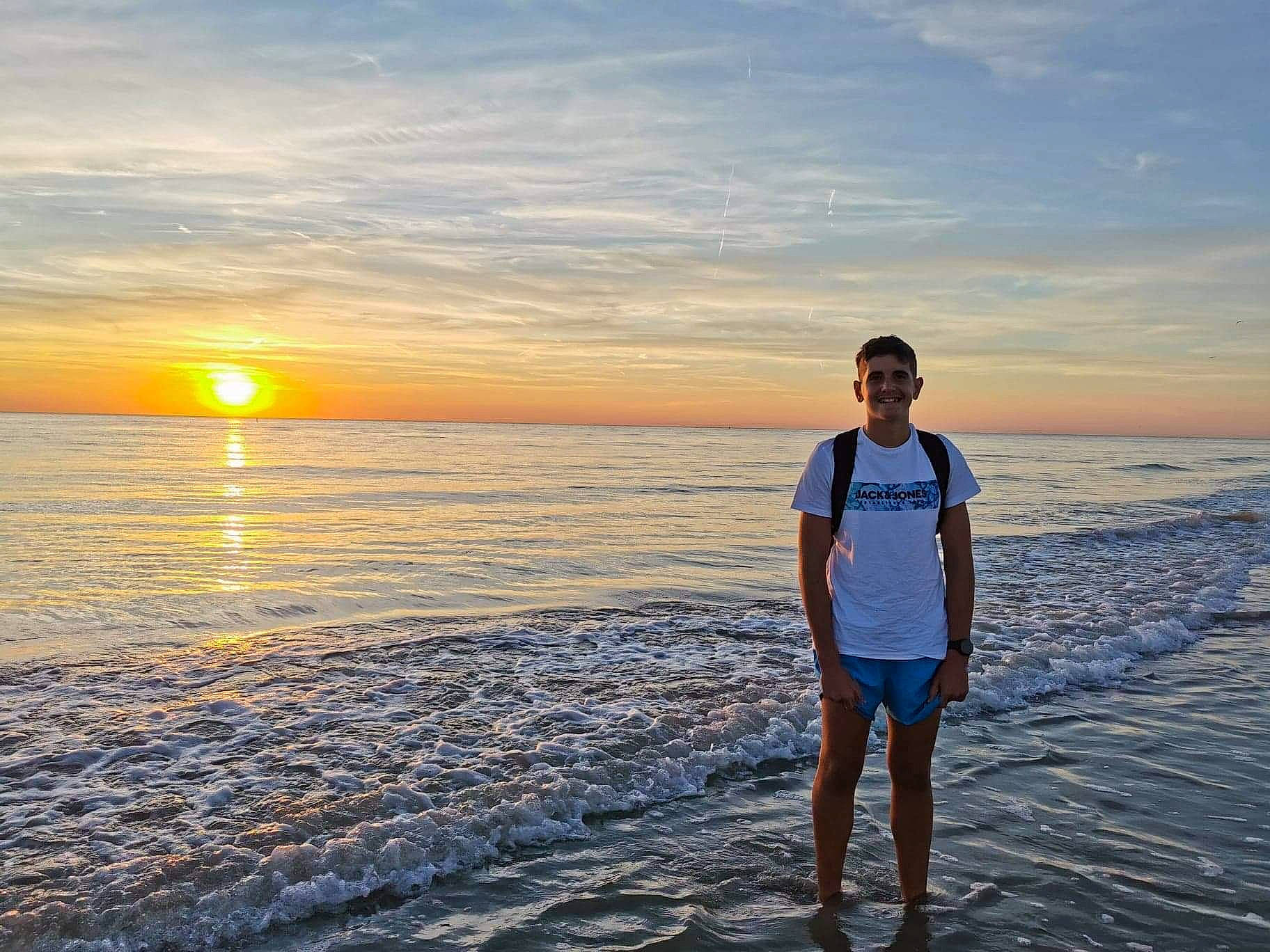 Gabryel participe au concours pour gagner de l'argent avec cette photo : beach, calm, cloud, coastal_and_oceanic_landforms, dusk, flash_photography, happy, horizon, joy, landscape, leisure, light, people_in_nature, people_on_beach, person, shorts, sky, sunlight, sunrise, sunset