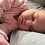 baby, sleeping, infant, pink_clothing, pajamas, hand, face, peaceful, soft_surface, bed, portrait, child, newborn, rest, cute, cozy, skin, head, closed_eyes, relaxation