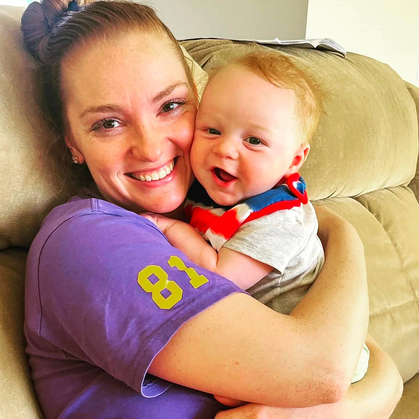 Parker is registered to the contest to win money with this photo: abdomen, baby, blond, cheek, chest, child, comfort, couch, face, facial_expression, fun, gesture, happy, head, iris, joy, person, skin, smile, t_shirt