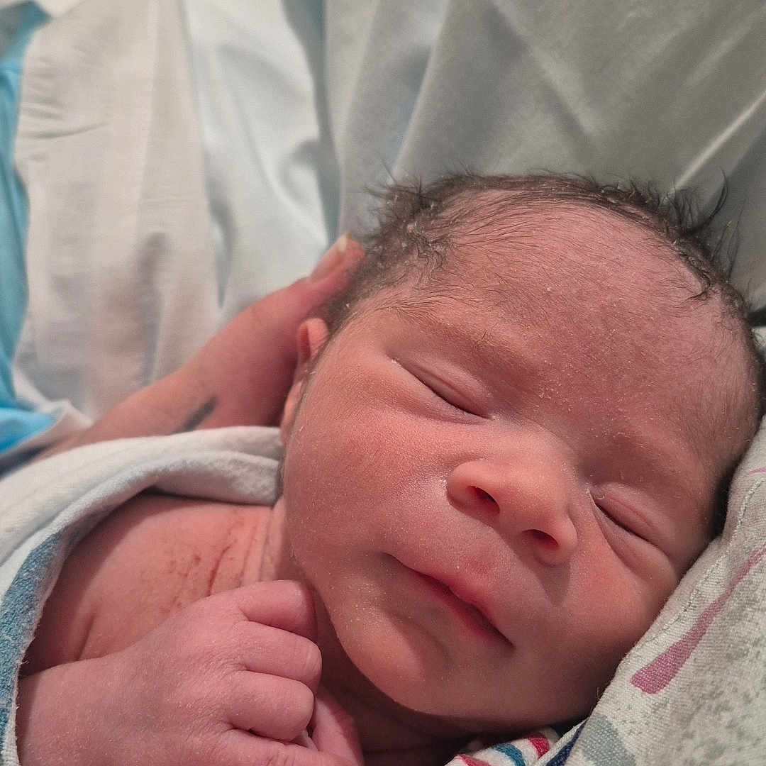 Malikhai is registered to the contest to win money with this photo: architecture, baby, bed, bedroom, blanket, building, clothing, face, furniture, glove, head, hospital, indoors, newborn, person, photography, portrait, quilt, sleeping, towel