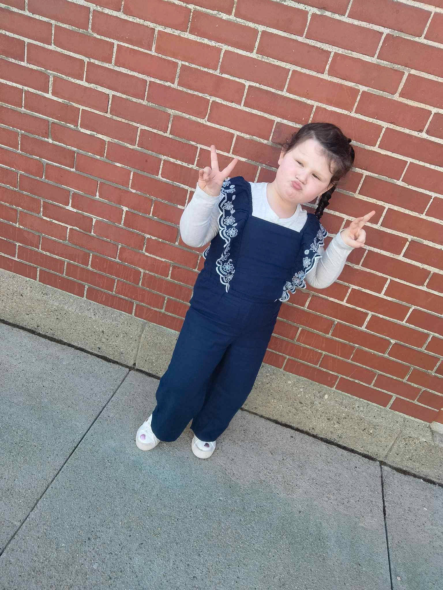 Lilli is registered to the contest to win money with this photo: active_pants, asphalt, brick, brickwork, child, denim, elbow, electric_blue, flash_photography, flooring, gesture, happy, human_leg, knee, person, road_surface, sleeve, sportswear, sweatpant, t_shirt