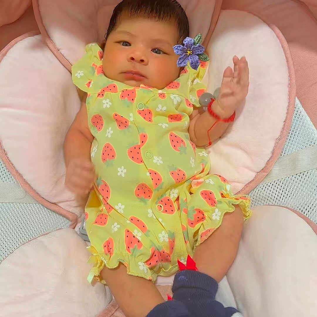 Naomi Valentina joined the competition — help win amazing prizes! baby, infant, child, portrait, lying_down, smiling, face, eyes, hair, watermelon_pattern, green_outfit, pink_blanket, plush_toy, stuffed_animal, flower, wrist_bracelet, nursery, indoor, soft_bedding, cute
