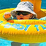 Jalil a rejoint le concours — aidez-le/la à gagner de superbes lots ! baby, infant, pool, water, float, inflatable, sunglasses, hat, dinosaur_pattern, yellow, blue, summer, sunny, child, outdoor, swimming, water_toy, cute, fun, relaxing