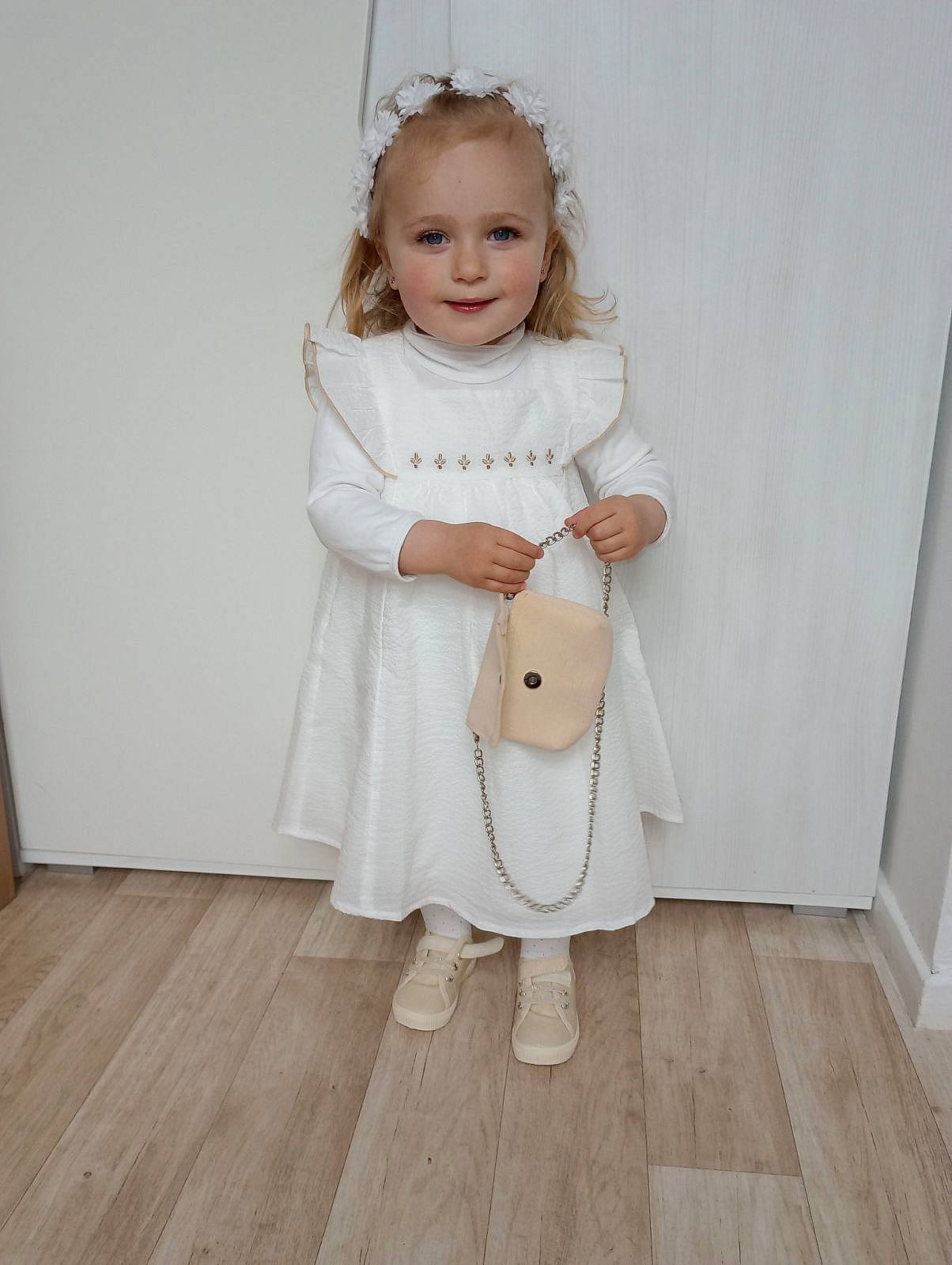 Emma a rejoint le concours — aidez-le/la à gagner de superbes lots ! baby_toddler_clothing, child, day_dress, dress, face, fashion_accessory, flooring, formal_wear, grey, hardwood, joy, laminate_flooring, one_piece_garment, pattern, person, sleeve, smile, toddler, waist, wood