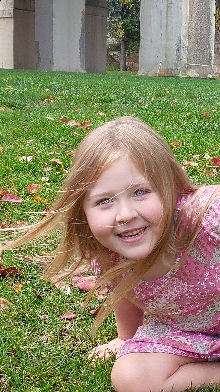 Skyler is registered to the contest to win money with this photo: beauty, botany, eye, facial_expression, fun, grass, grass_family, green, groundcover, hair, hairstyle, happy, head, joy, leaf, leisure, people_in_nature, person, pink, plant