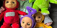 Luchi joined the competition — help win amazing prizes! baby, smiling, laughing, plush_toy, teletubby, red, green, purple, yellow, couch, striped_pants, child, indoor, happy, toy, person, fabric, hand, foot, smartphone