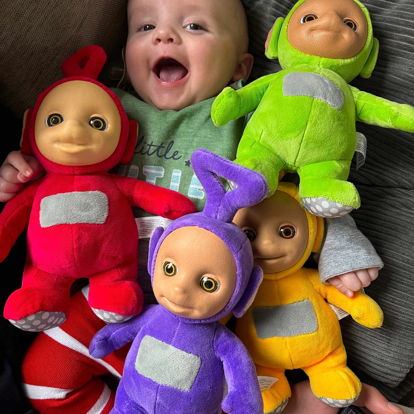 Luchi joined the competition — help win amazing prizes! baby, child, couch, fabric, foot, green, hand, happy, indoor, laughing, person, plush_toy, purple, red, smartphone, smiling, striped_pants, teletubby, toy, yellow
